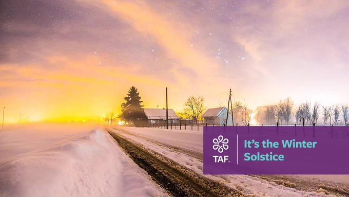 A house, barn, and a few scattered trees occupy a rural, snowy landscape at dusk. The overlaying text says, “It’s the Winter Solstice.”