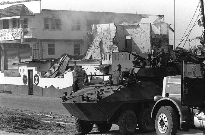 MilitaryJournal's tweet photo. Marines of Company D, 2nd Light Armored Infantry Battalion, stand guard with their LAV-25 light armoured vehicles outside a destroyed Panamanian Defense Force building during the first day of Operation Just Cause, 20 December 1989. #MilitaryHistory https://t.co/Yavie8cOPT