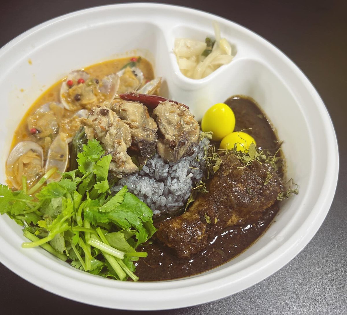 hm_currycell's tweet photo. 埼玉小川町『curry＆noble強い女』
1/2.3の2日間限定提供
「漆黒チキンとアサリの究極カレー」

美味いと旨いの両方があるカレーでした。
強い女さん（変な言い回し）、もともと強くて美味しかったのだけど、イベントの回を重ねるにつれどんどん凄みを増してきました。

炭で炊いたブルーグレーのご飯がアイコンとなりつつありますね。

いよいよ明日は最終日。
16時までの営業となります。

#おせちもいいけど！
西武池袋本店「東京カレーカルチャーDX にっぽんカレー列島 冬の熱々笑福篇」
12/27〜1/3の8日間 西武池袋本店7階催事場にて開催中！

#にっぽんカレー列島 #東京カレーカルチャー #西武池袋本店 #カレー #スパイスカレー #カレー好きな人と繋がりたい