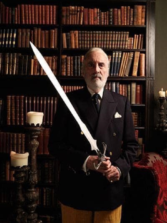 HorrorHammer1's tweet photo. Christopher Lee holding a sword in a library! https://t.co/wdC3MQAyq1