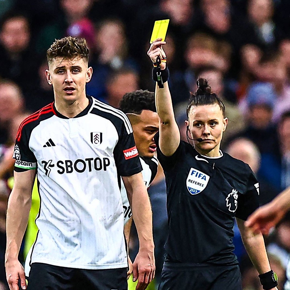 Rebecca Welch showing yellow card to Tom Cairney