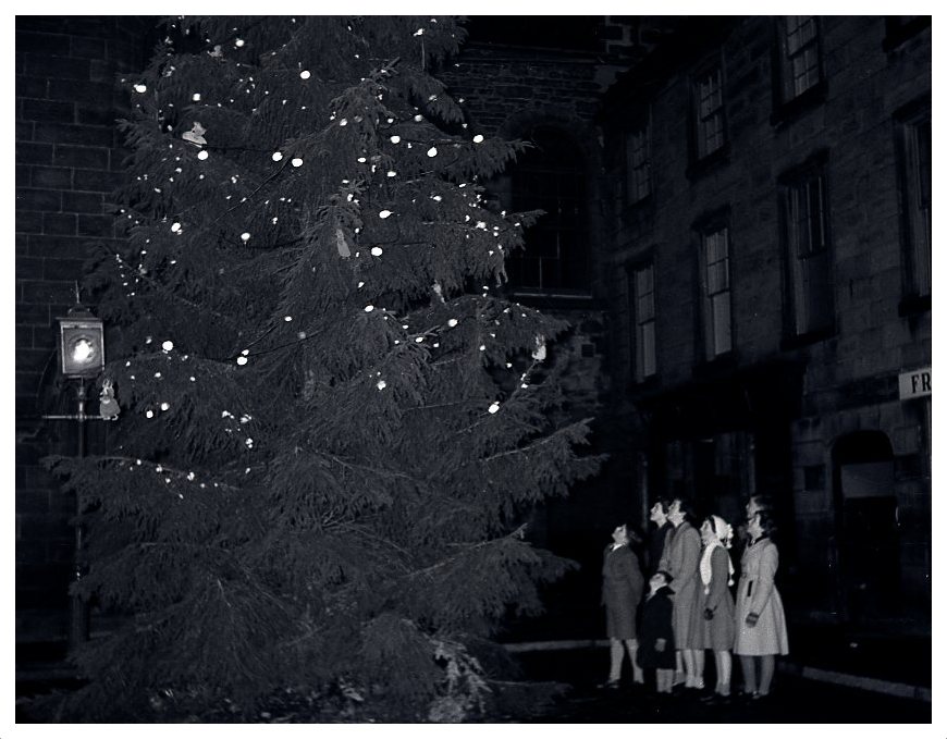 ForresHeritage's tweet photo. A Very Merry Christmas and a Happy New Year from all at the Forres Heritage Trust. 
This is the first large illuminated Christmas tree erected at the Cross, which was in December 1953. The first Christmas Tree in the Town, was put up the previous year, 1952, in the Market Green. https://t.co/ed8Q0lTvWY