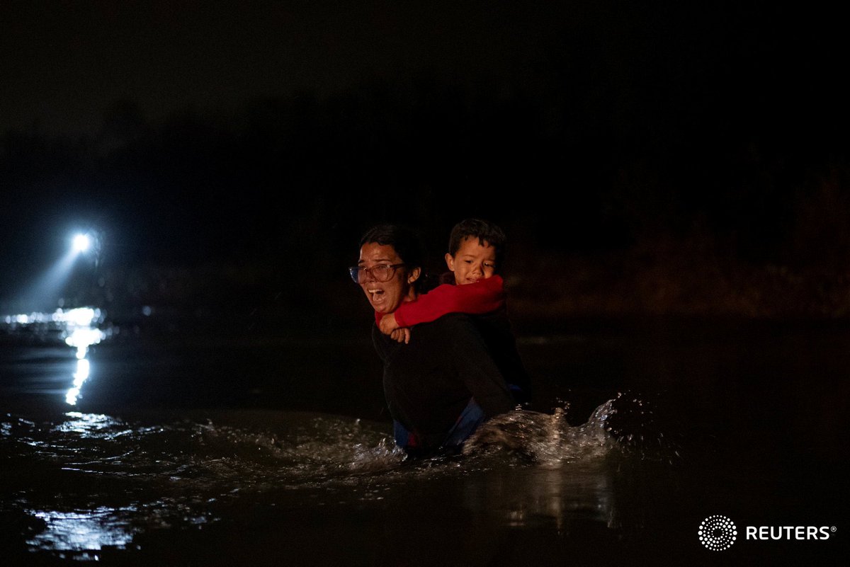 A woman, who wished her name and country of origin to remain anonymous, yells for help as she carries her son on her back through the current. The woman and her son were the last two people to cross the river of a group of several hundred migrants. Photo by @orr_photo