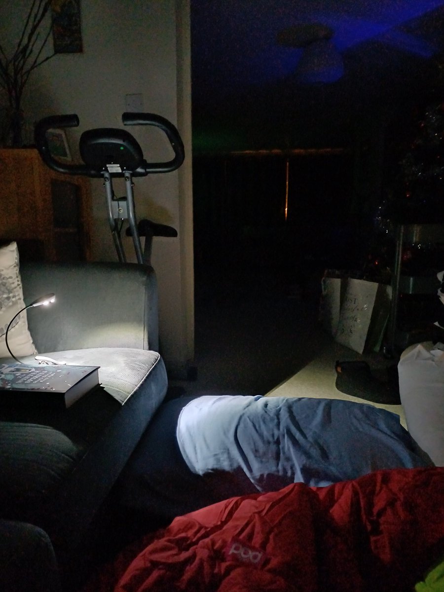 This year we are on the lounge floor in our own house. Here's the view, complete with unearthly light outside the curtains. #duvetknowitschristmas #exercisebikebingo #creepybooks #potentialalienabduction