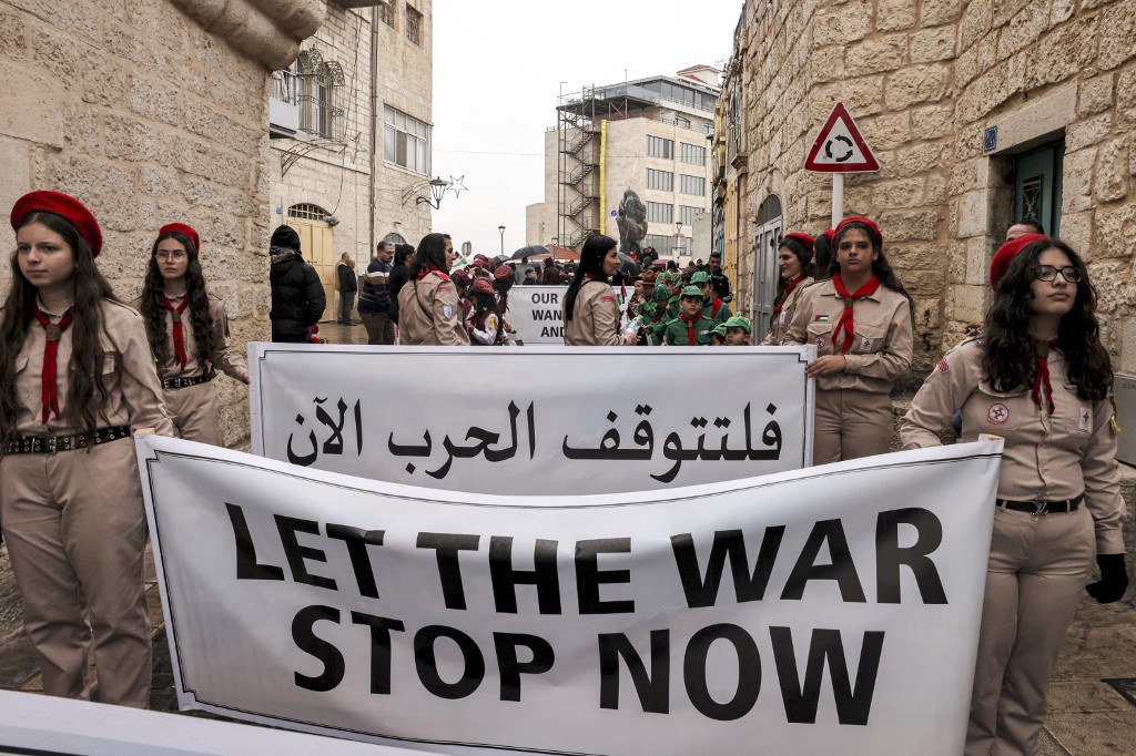 PSCupdates's tweet photo. Palestinians in Bethlehem, for whom Christmas is cancelled, deliver a message to the world.  Today Israel will continue to rain bombs on Gaza as across the world people exchange messages of peace. Peace can only be built on a foundation of respect for the rights of all. https://t.co/0ReBy5sum9