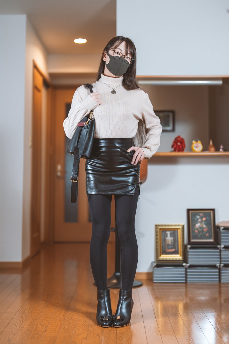 オフホワイトのトップスにフェイクレザーのタイトミニスカートと透けない黒タイツとショートブーツの組み合わせの写真です。