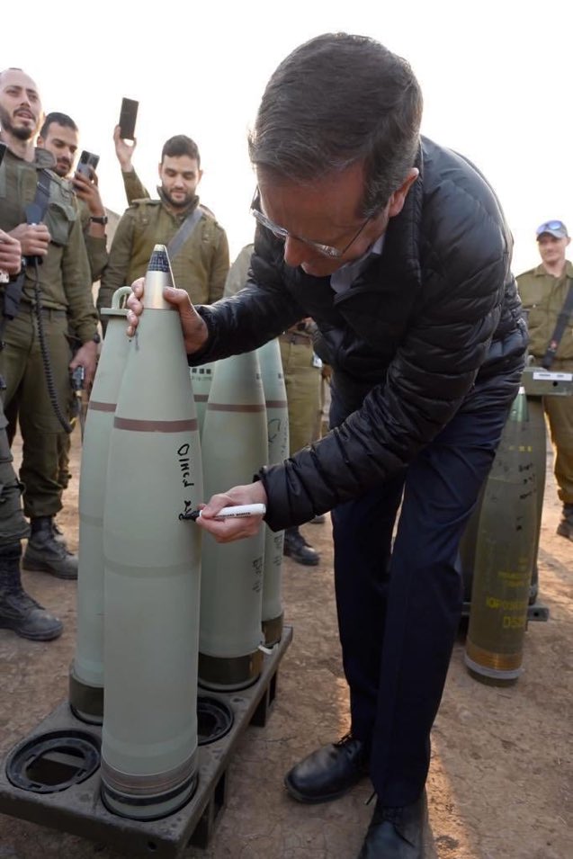 Israeli President Isaac Herzog writing a message on a bomb due to be dropped on Gaza.