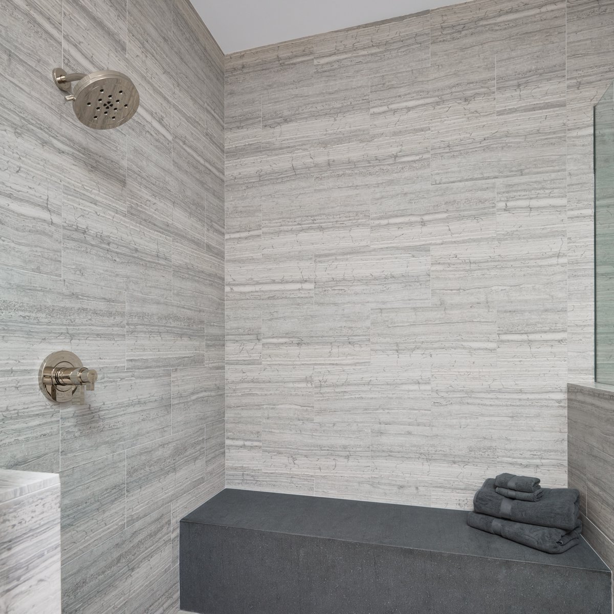 This shower has been transformed into an elegant, sophisticated space with natural stone. Click here to learn more: ecs.page.link/SSjCC

Featured Products: Haisa Blue 12 x 24 Marble (shower walls) &amp; Italian Basaltina Basalt (shower bench) 

#marbleshower #arizonatile