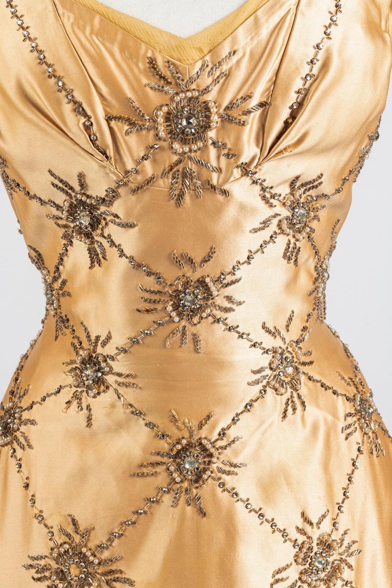 kateStrasdin's tweet photo. A lattice work of beaded flowers by the embroiderers employed by #NormanHartnell in the #1950s. He was one of the few high end dressmakers to have his own #embellishment workshop in house, rather than outsource to independent couture embroiderers. Just lovely @Fashion_Museum https://t.co/oPRbkS3T6I
