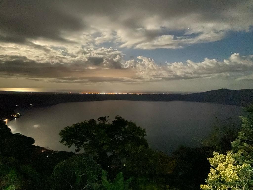 Moonlight over Laguna de Apoyo, Nicaragua, with the lights of the city of Granada and Lake Cocibolca in the background.