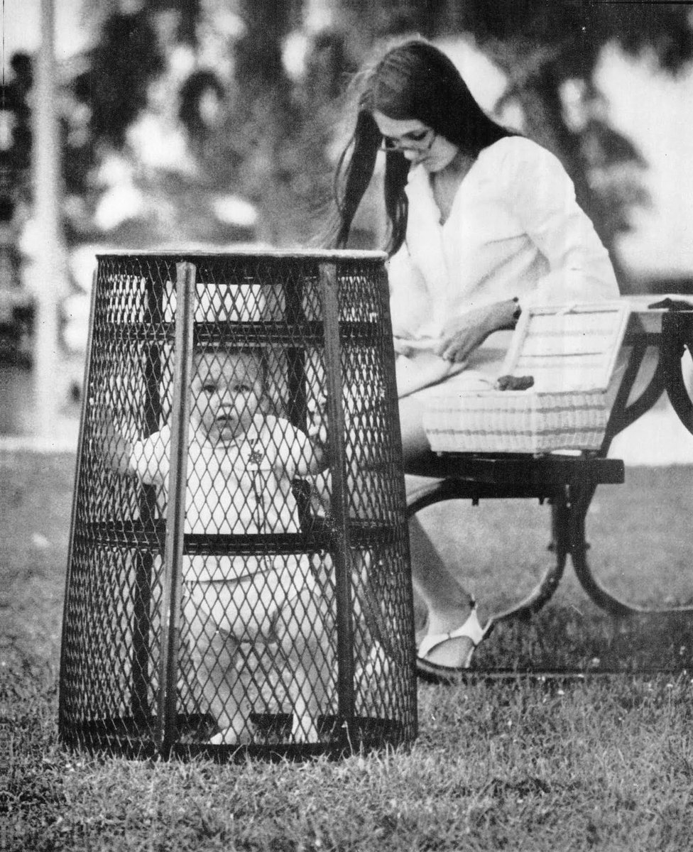 TimeTriping's tweet photo. @fasc1nate A mother uses a trash can to contain her baby while she crochets in the park, 1969 https://t.co/W2kPzHQyTV