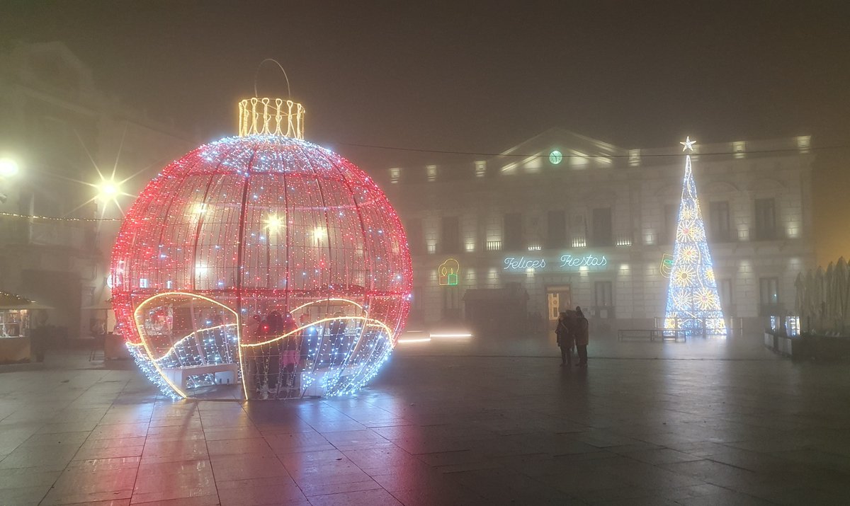 Plaza del pueblo con niebla. El arbol-cono y la esfera Navideña ya se ven instalados en muchos pueblos y ciudades. Antes en cada sitio se las ingeniaban de forma artesanal.