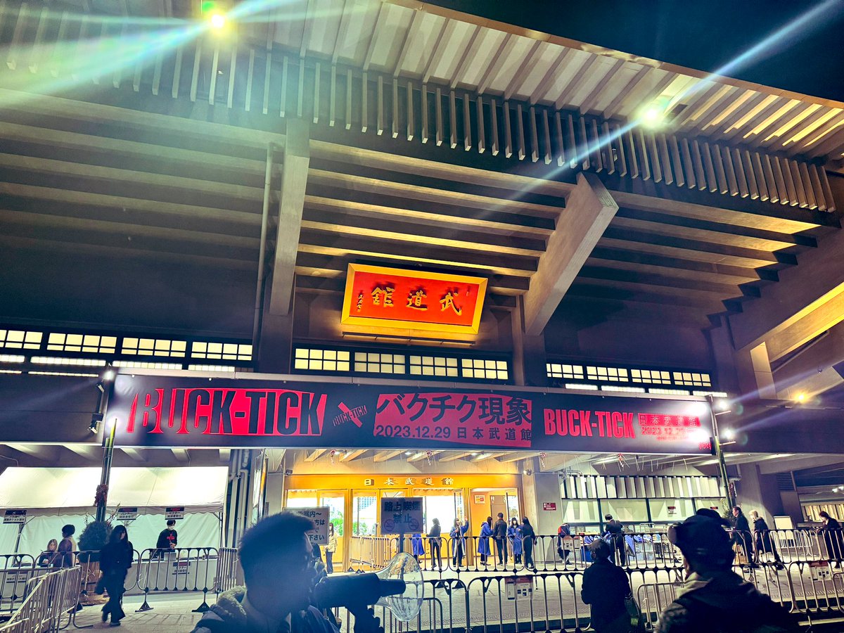 ShowAyanocozey's tweet photo. 「バクチク現象」を目撃に日本武道館へ。
冒頭、色々な事を考えてしまい、うっかり涙が込み上げて来たのだけど、始まった途端に引っ込んでしまった。
何というか、メンバーの皆様の表情に感傷的なものや悲壮感みたいなものが微塵にも見受けられなかったから。
ステージングは怖いぐらい通常運転。
でも、曲が進むにつれ、わかった事がありました。
あっちゃんがいないという現実を、この会場にいる誰よりも真っ直ぐに受け止めているのがこの4人なのだと。
実際センチメンタルな演出は一切無く、むしろ何事もなかったかのように堂々とした演奏が続き、ああそうか、これがBUCK-TICKの覚悟なのか、と納得してしまった。

とは言え、櫻井敦司という圧倒的な存在の大きさが浮き彫りになったのも事実で、同期の声や映像だけでは当然彼を補えない事もはっきりした。
が、その分今まで知っていた筈の楽器隊の演奏力と表現力の凄まじさ、そしてそれぞれのチャーミングさ、加えて楽曲の秀逸さに改めて気づく、新たに発見する、という不思議体験も。
何しろ（武）、いつも通りにクールで疾走感に満ちたパフォーマンスを畳み掛けて、本編は終わった。

アンコールでは4人がそれぞれマイクを握りメッセージをくれました。
ユータさんは涙で声を震わせながら、時に言葉に詰まりながらも「これからもBUCK-TICKはずっと5人です」と言ってくれました。
アニイは「ド不良の弟がこんな立派なコメントを出来るようになるとは…」と和ませてくれました。
ヒデさんは「今日ここに来るまで、みんな不安だったよね。でもパレードは続きます」と安心させてくれました。
今井さんは「あっちゃんが死んで、悲しんだり泣いたりしてもいいけど、苦しまないで。死んだ事より、彼が生きていた事を大事にして。来年は新曲もアルバムも出すよ」と言って、乾杯してくれました。
そして「覚悟しといて。次は3人になるし、その次は2人、最後の1人は俺かな？」と笑わせてくれました。

…あかん。
興奮のあまり、ツラツラとラストまでヘタクソなレポを書きかけていたのだけど、そういう事ではなかった。よし、即中止。

BUCK-TICK。
本当に、本当にすごいバンドだ。
公演中、何度も何度も考えた。
俺達なら、氣志團ならどうする？と。
我々がどうなって行くのかなんて、そんな未来は占えっこないけれど、ガキの頃から憧れ続けた偉大なる大先輩が、今日こうしてロックバンドの新たな在り方を切り拓いてくれた。

2023年最後に、こんなすごいステージを魅せて頂き、心より感謝とリスペクトを。
ありがとうBUCK-TICK！
愛羅武BUCK-TICK！

追伸：武道館の楽屋はメンバールーム以外に、各自の部屋も設けられていたのだけど、一番手前にはもちろん「SAKURAI ROOM」がありました。

みんな、「永遠」は実在するよ！