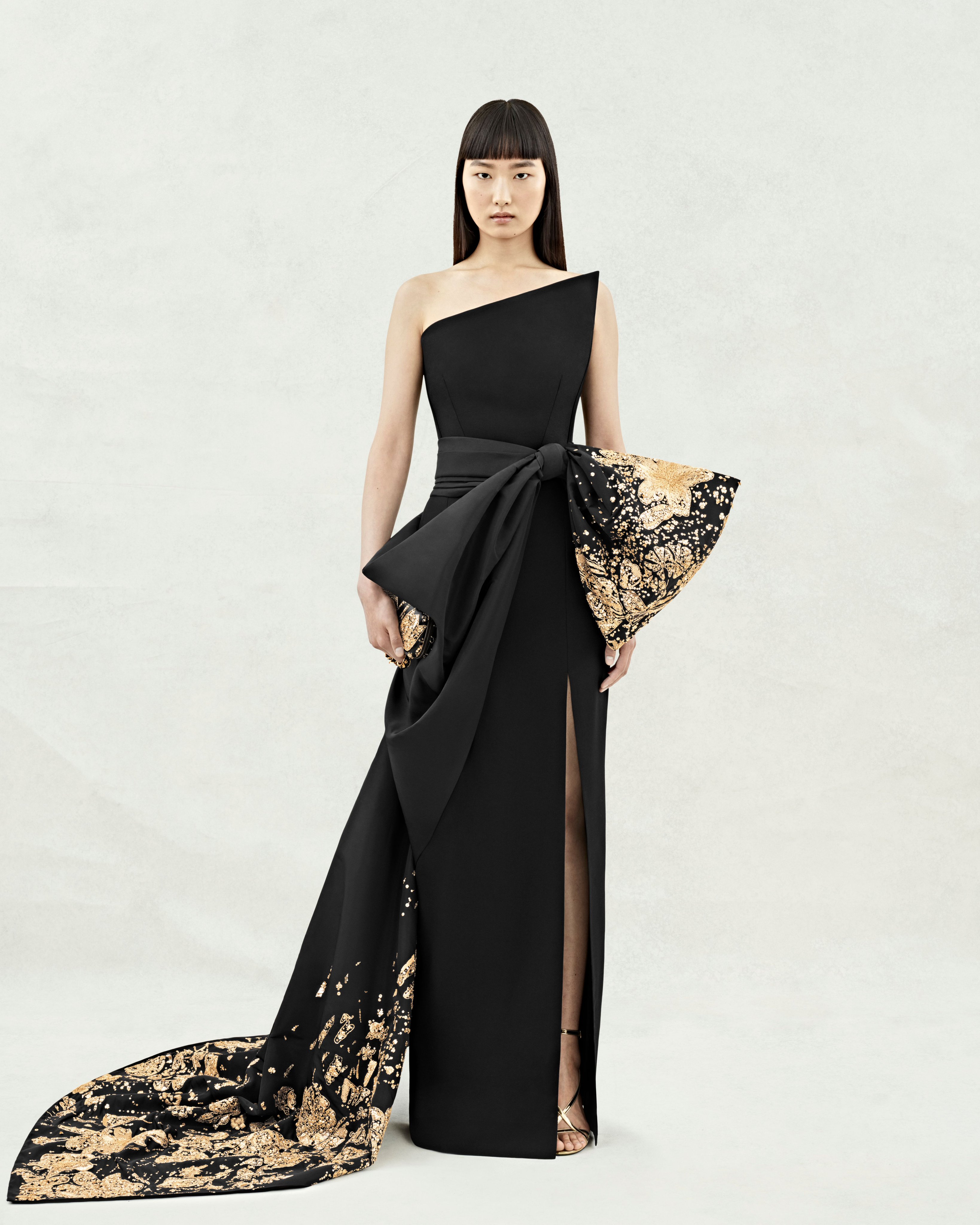 Alexander McQueen on X An asymmetric bustier dress in black with gold hammered sequin flower embroidery and a bow train. Discover McQueenPreSS24 https t NiJyVlwGab https t Oqbl6UQehf X