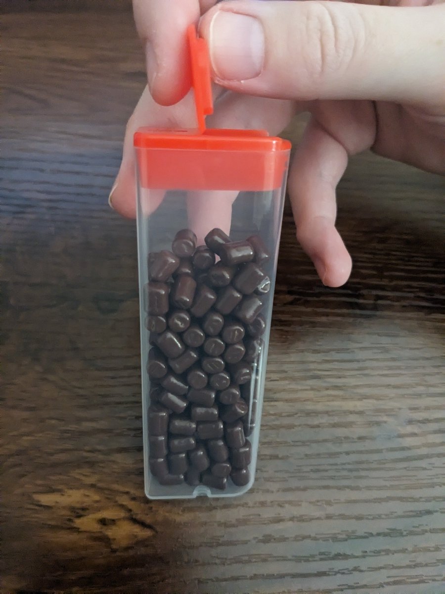 MementoMousie's tweet photo. got these lil chocolatey candies
not only are they kibble/mouse pellets shaped &amp; very satisfying to eat

but also they come in this convenient pocket sized shaker that makes a lovely pavlovian triggering noise, so u can give ur dog girl positive reinforcement throughout the day https://t.co/oh8EUAc8Ns