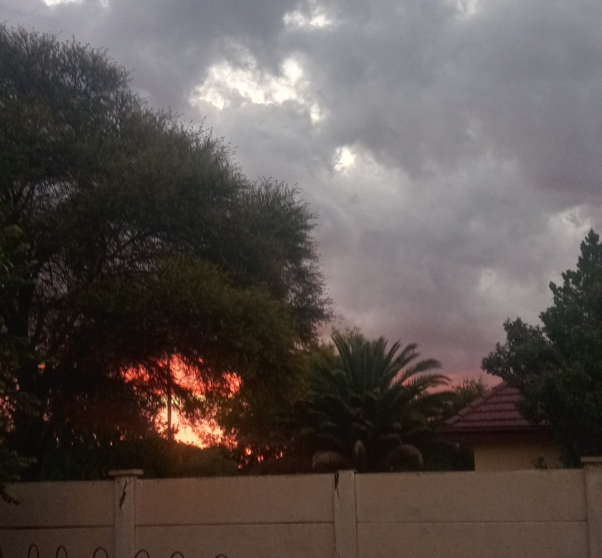 Red Fiery Sunset with Yellow Spot in the Middle through the Tree, together with Thunder Clouds on New Year's Eve...Beautiful Sight..Goodbye 2023..