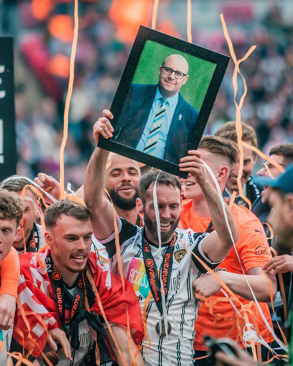 Our longest-serving player, Jim O'Brien, holds Jason's photo aloft amid the celebrations.