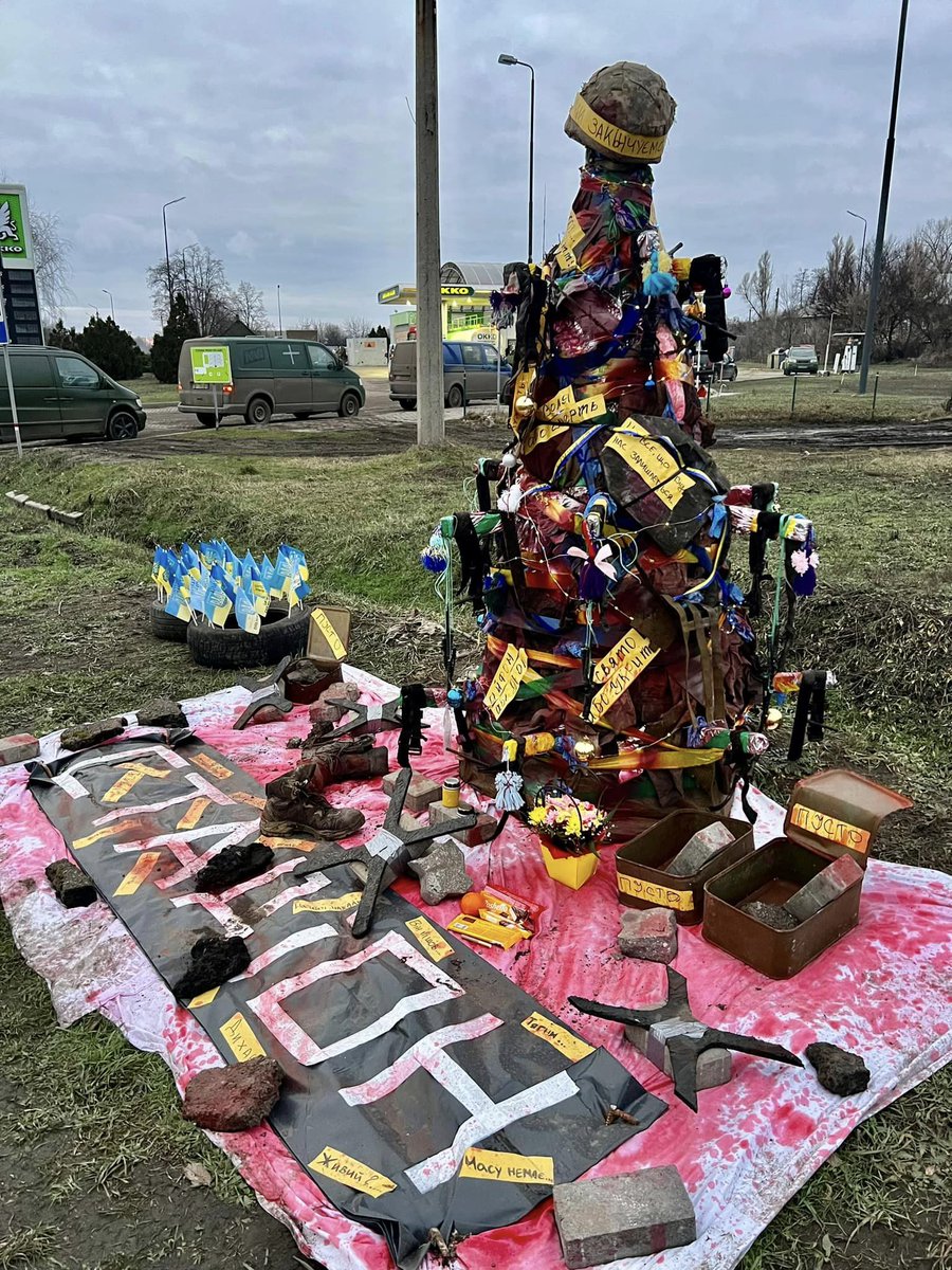 HromadskeUA's tweet photo. На фото — ялинка в Костянтинівці, на шляху до українських позицій, де траса повертає на Бахмут. На ній замість іграшок речі загиблих та поранених українських бійців

Фото: Facebook / Iurii Tyra https://t.co/H9G8RIb1xx