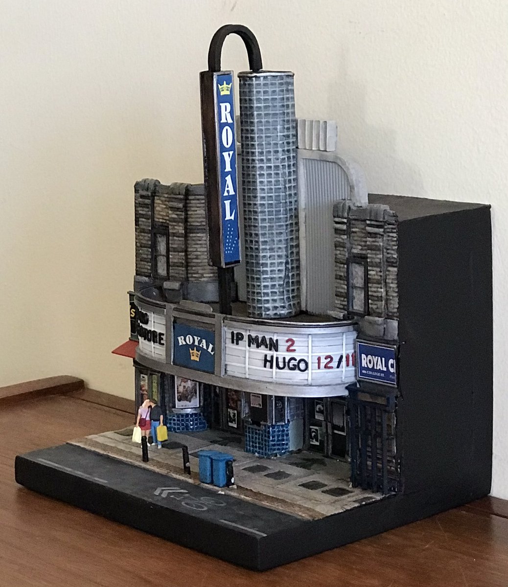 wolfhard's tweet photo. For Leslie’s Xmas present I scratch-built a model of a movie theatre we went to a lot when we were dating. 

The movies on the marquee and the posters are all nice theatre experiences we had in Toronto (we saw Hugo the night before our wedding) https://t.co/FXucPhv0HK
