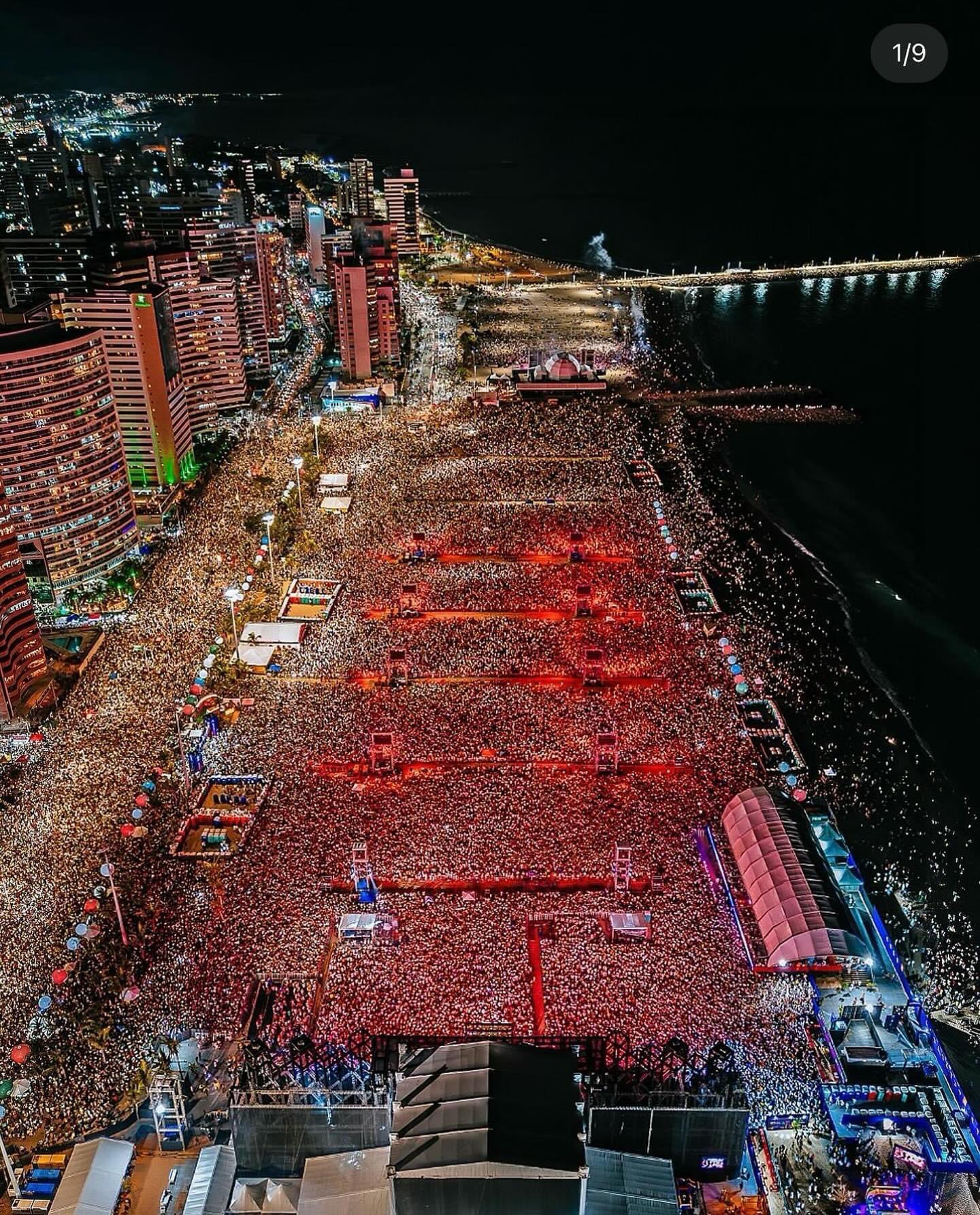 Foro área mostra o Aterro da Praia de Iracema lotado com pessoas na praia e também nas pistas de frente ao palco e até a praia de Iracema