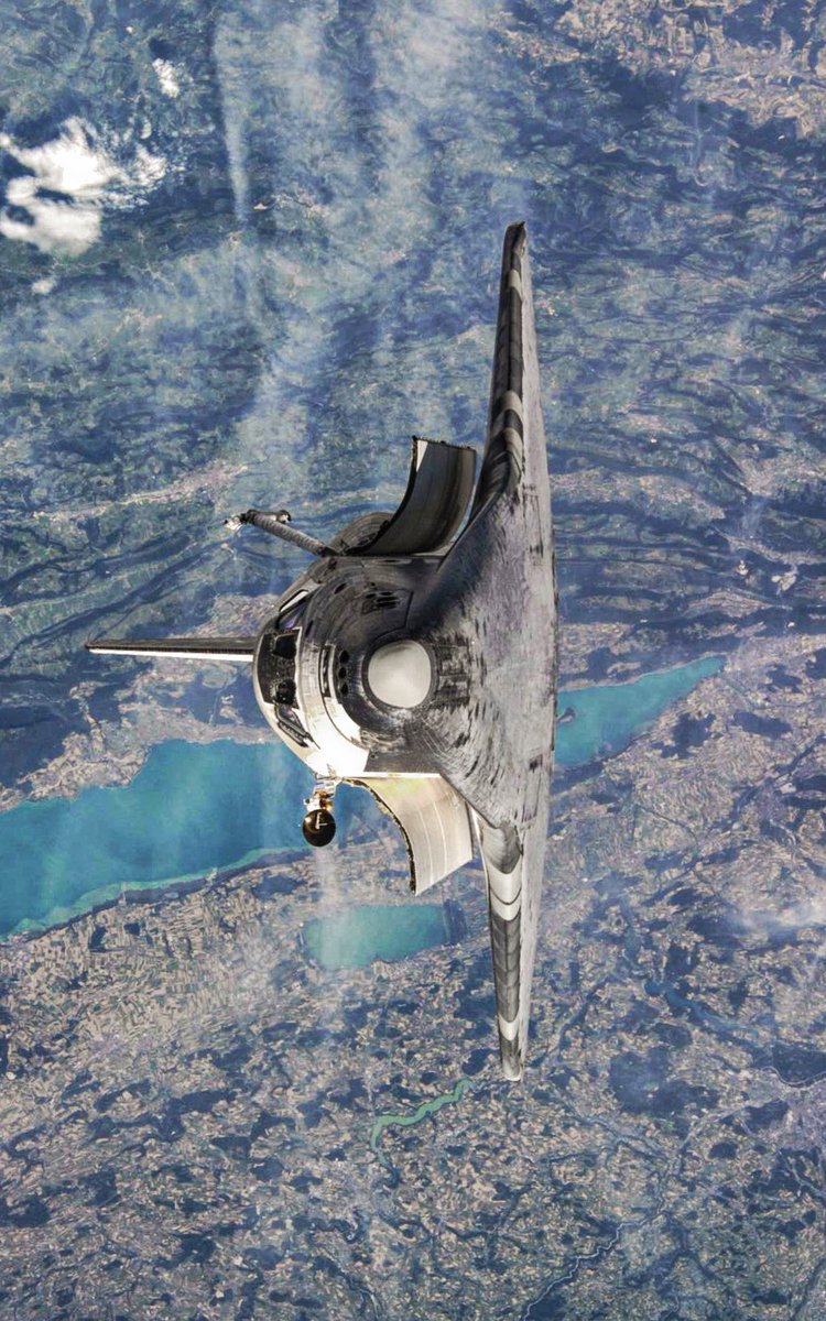 JPMajor's tweet image. Space Shuttle Discovery photographed from the ISS during the 1st R-Bar Pitch "backflip" maneuver on July 28, 2005. Lakes in western Switzerland near the border of France are visible in the background. (NASA photo # ISS011-E-11258)