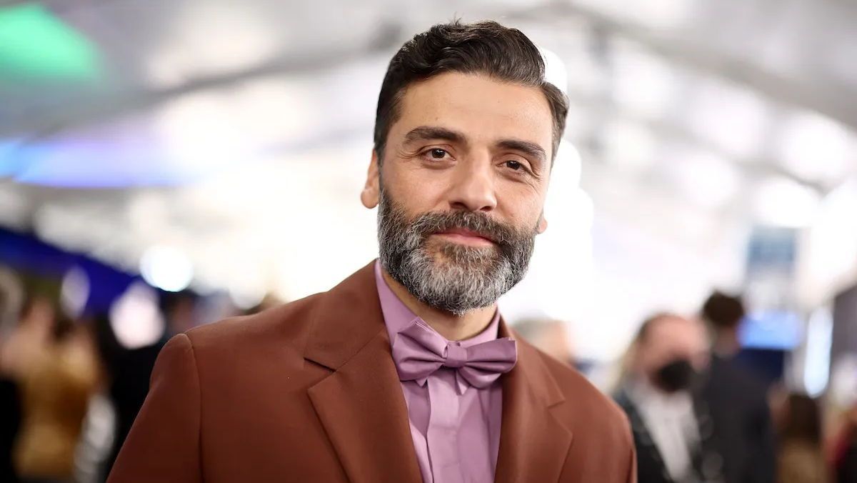 A photo of Oscar Isaac walking a red carpet