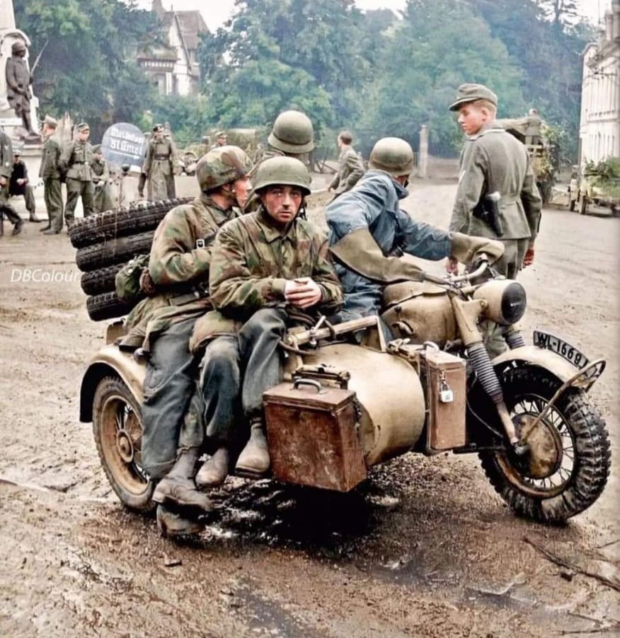 👉3 paracaidistas alemanes y un conductor de Motocicleta vistiendo mono y guantes de protección en la famosa Motocicleta BMW R75 con sidecar en la carretera dirección Rouen en el pueblo francés de Grand-Bourgtheroulde durante la retirada del Ejército Alemán, Normandía, Agosto 44