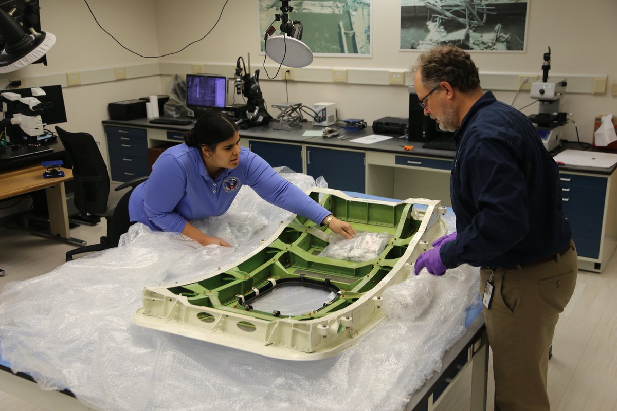 Leani Benitez-Cardona, NTSB aerospace engineer, and Matthew Fox, NTSB chief technical advisor for materials, unpacking the door plug Sunday from Alaska Airlines flight 1282, a Boeing 737-9 MAX, in the materials laboratory at NTSB headquarters in Washington, D.C.