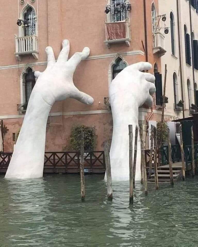 Está en Venecia,Italia 🇮🇹, se llama “Soporte” manos salen del agua dando la impresión de sujetar el edificio, obra realizada por Lorenzo Quinn. Escultor italiano, residente de Casteldefels, municipio de Barcelona. España.