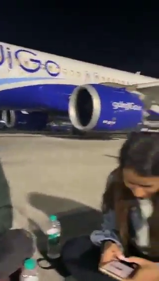 ANI's tweet photo. In a viral video, passengers of a Delhi-bound IndiGo flight diverted to Mumbai (confirmed by airport sources) due to operational issues are seen eating and sitting on the airport tarmac at Mumbai Airport.

(Screengrabs from viral video) https://t.co/xNdiW7HqUv