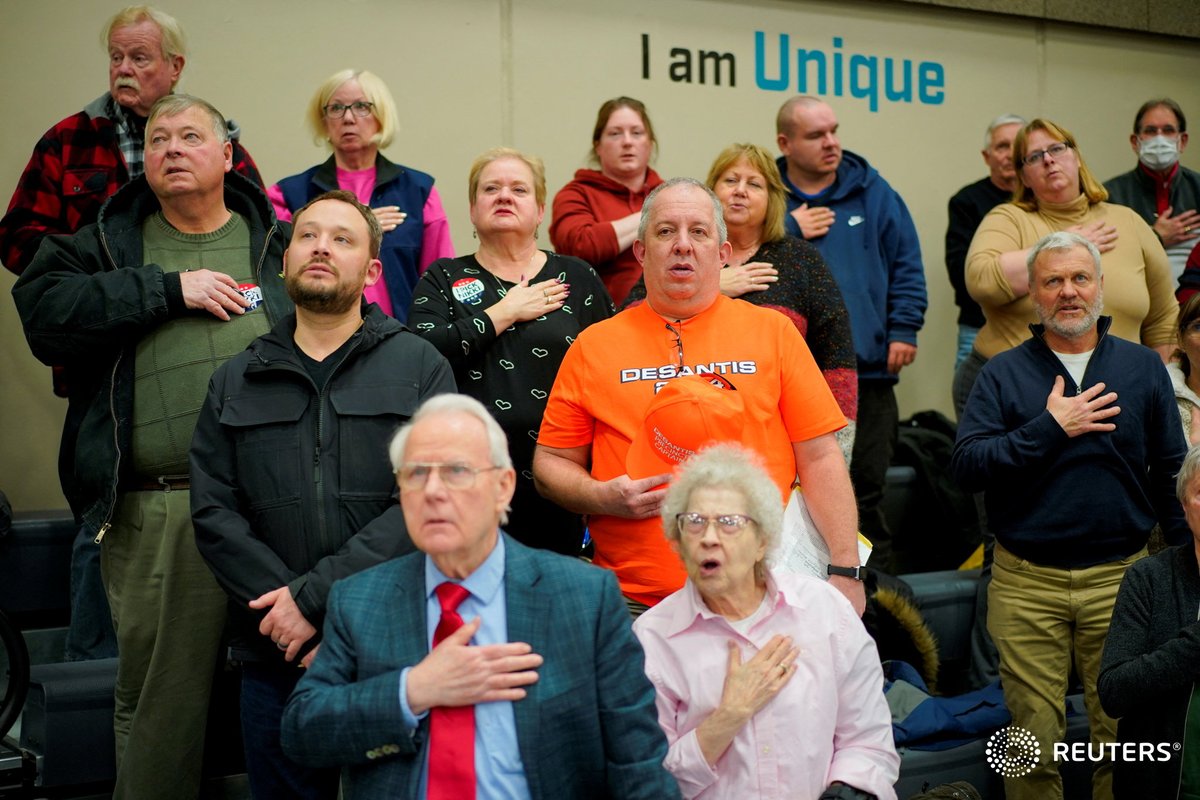 People say the Pledge of Allegiance ahead of the vote at a caucus site to choose a Republican presidential candidate at Fellows Elementary School, in Ames, Iowa. Photo by <a href="/orr_photo/">Cheney Orr</a> #IowaCaucuses