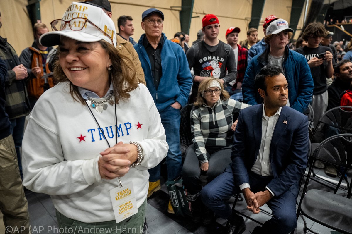 .@VivekGRamaswamy, right, sits in the audience while waiting for his turn to speak as @realDonaldTrump speaks at a caucus site at Horizon Events Center, in Clive, Iowa, Monday, Jan. 15, 2024. (@AP Photo/@andyharnik )