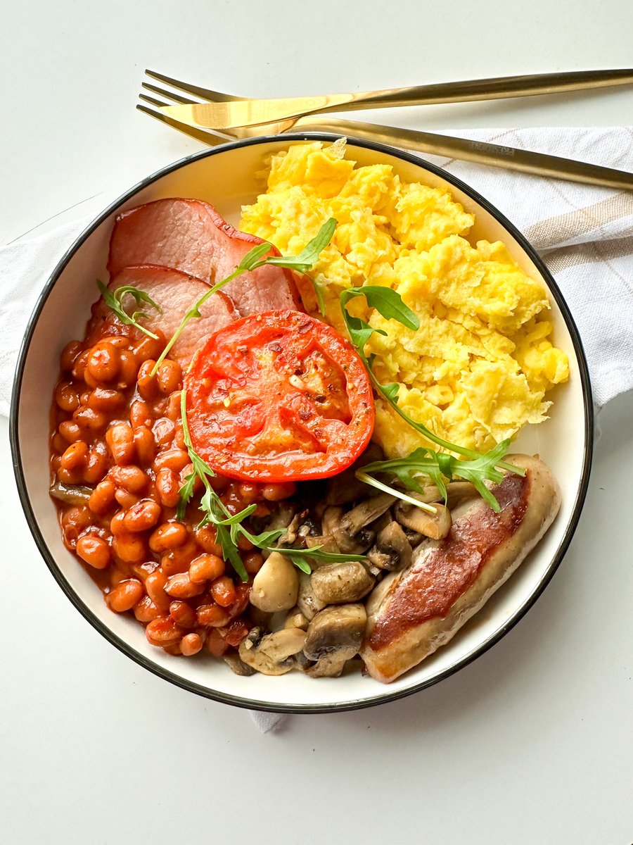 Good morning ☀️ Here I have parmesan scrambled eggs, bacon, baked beans, garlic mushrooms, tomato & a pork sausage 🍳🫘🥓🍄🍅 @_theeats