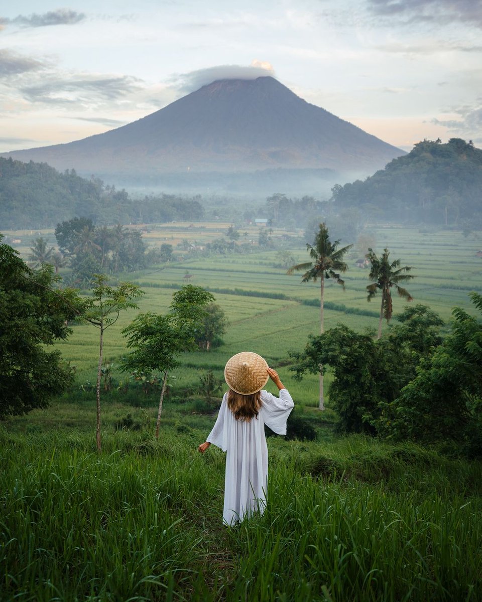 As the sun rises over Bali's rice fields with Mount Agung's live volcano in the backdrop, it's the perfect moment for a breathtaking photo. Embrace the dawn's beauty! 🌅🌾 
📸@allaboutwanderlust_
#WonderfulJourney #WonderfulIndonesia #BaliSunrise #MountAgung #PhotographyParadise