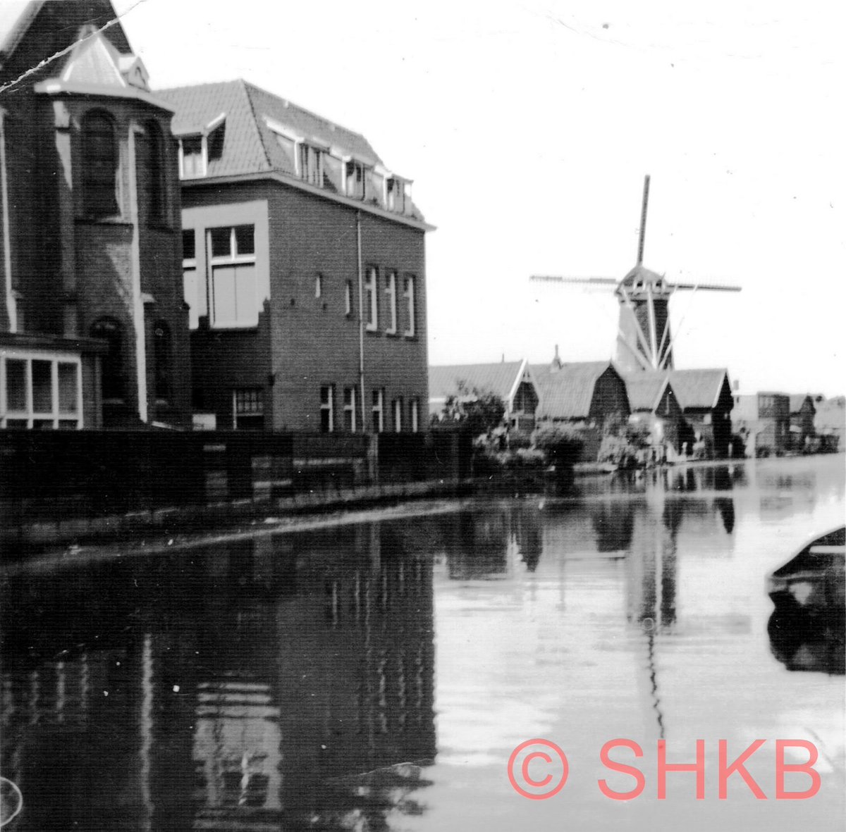 HistBodegr's tweet image. Op de foto zien we de kapel en het #Pensionaat van de zusters #Franciscanessen  aan de achterkant aan de #OudeRijn in Bodegraven. Molen de #Arkduif op de achtergrond.