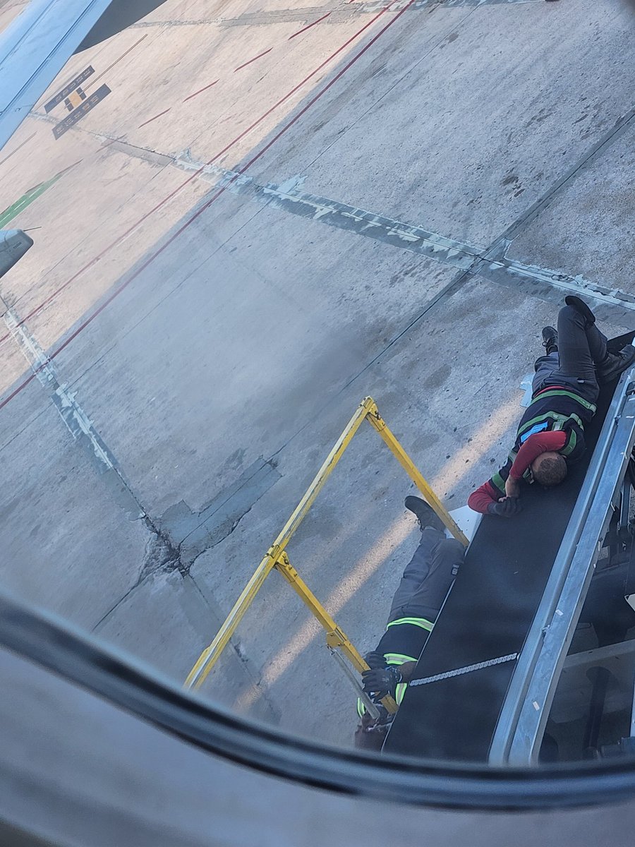 Josueceballo's tweet photo. Empleados de un avión que está abordando, echando una pavita en la correa de carga de maletas. #RepublicaDominicana #Inagotable https://t.co/T4bfyWg1dy