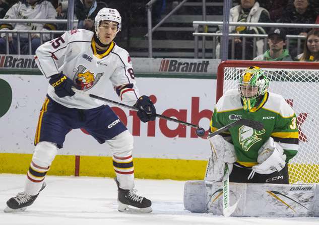 Carter Lowe of the @barriecoltsOHL gets his stick broken by a point shot by teammate Connor Punnett in front of Michael Simpson of the @LondonKnights during their game Friday night at @BudGardens