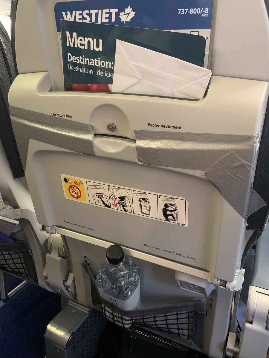 LoveMy7Wood's tweet photo. Hey, ⁦@WestJet, we just boarded flight 2198, and this is what I have. I paid extra for emergency row seats and I can’t use my tray table. Duct tape instead of fixing it. What’s that all about and again, I paid extra for these seats. More for less. https://t.co/vFhBJXu7Vz