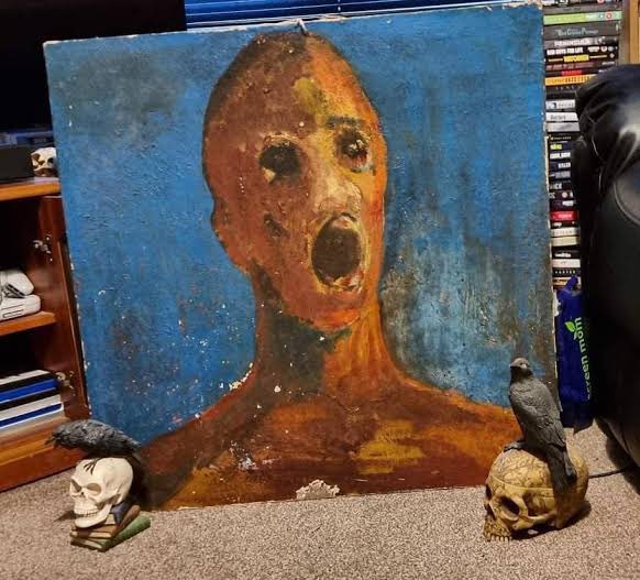 madamefeyella's tweet photo. Sean Robinson who took this photograph of The Anguished Man painting believes that it is a haunted painting.

His grandmother had told him stories about the painting when he was younger- the artist had committed suicide after the painting was completed; the artist had mixed his own blood in the oil paint; that she was sighting a dark ghostly figure in the house -- and claimed that the painting was the source of strange noises... such as the sound of a man crying.

Shortly after Sean Robinson brought The Anguished Man into his home, he and his wife started to see a dark figure of a man within their home. 
Sighting of the entity progressed in addition to the sound of a man crying and other strange noises. 
Sean Robinson who initially doubted stories about supernatural and paranormal activity now believes the information provided by his grandmother. He is convinced that the painting is haunted by an evil entity

He said-

“We have heard crying coming from the corner of our bedroom. We started seeing the dark figure standing at the bottom of the bed, just apparently staring at us. It seems to be a middle aged man but his features are not very clear.". His wife was so frightened that she refused to stay under the same roof as the painting.”

The Anguished Man has been studied by a number of paranormal investigators

According to Sean, Mysteria Paranormal has visited some of the most documented allegedly haunted locations in the UK with the painting in hand.

On Paranormal Phenomena, Sean Robinson's account of one event that occurred on this ghostly tour is documented by Stephen Wagner
“It was on the evening of 18 May 2013 at Chillingham Castle that a group of people experienced events that were both terrifying and unexplained. None of the guests were prepared for what was about to happen in the early hours of Sunday morning. The room went icy cold when a large, dark figure appeared in the middle of the séance circle. A large wooden bench banged on the floor of its own accord in response to John Blackburn's questions to the painting, then suddenly the bench was flipped upside-down violently by what was believed to be John Sage, one of Chillingham Castle's resident powerful spirits, who we think was showing his anger to a foreign, uninvited spirit to his castle.”

According to several sources, John Blackburn of Mysteria Paranormal has stated that the event was the strangest experience he has had in all of his years of supernatural / paranormal investigation. The alleged interaction between the spirits of Chillingham Castle and The Anguished Man was witnessed by over twenty paranormal investigators. With this in mind, it is often said that artists desire to 'live on' with their work. Perhaps the unidentified artist who created The Anguished Man achieved that goal in a disturbing way.