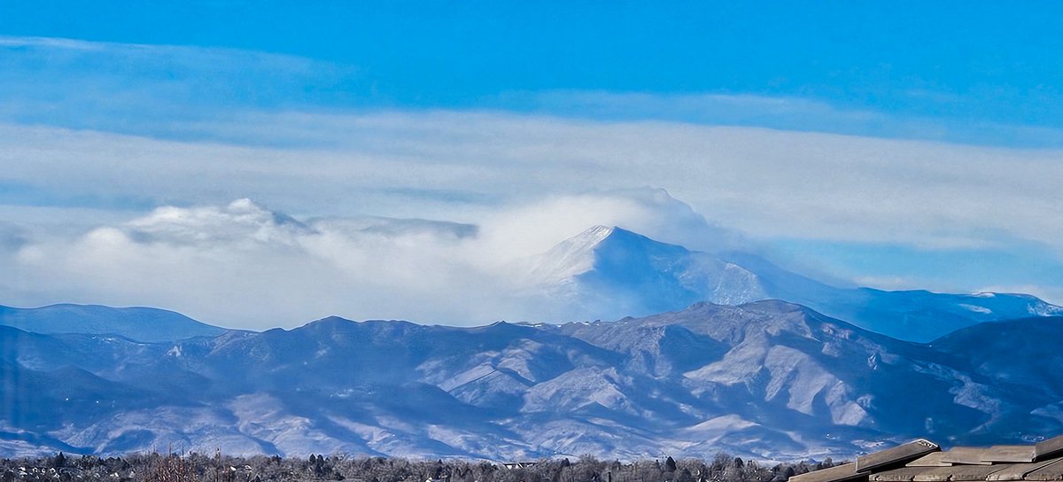 Indian Peaks (center-left) obscured by clouds/some light snow; parts of Mount Meeker and most of Longs Peak (center-right) obscured by clouds/some light snow. As seen from our deck in Broomfield at 2:33 p.m. #cowx
