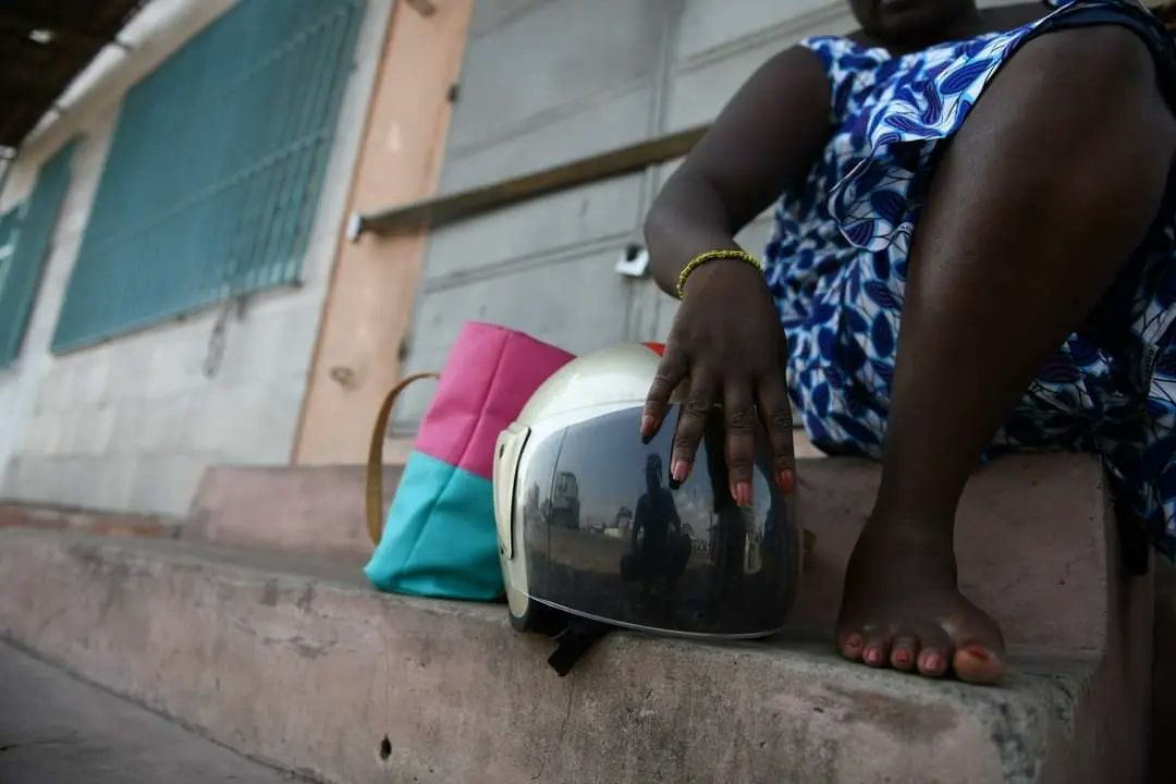butageoffrey's tweet photo. A woman with her helmet waiting to board a commercial motorbike to her destination.
In Togo, failure to wear helmets by passengers on two or three-wheel motorcycles is an offense and will be penalized for evaluating it by the National Police following a two-week  campaign. https://t.co/vVPqMfex6M