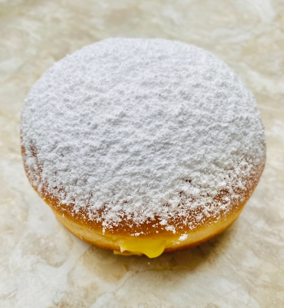 This ray of sunshine is a pillowy yeast-raised doughnut dusted with powdered sugar and filled with a silky pineapple/tangerine curd.
