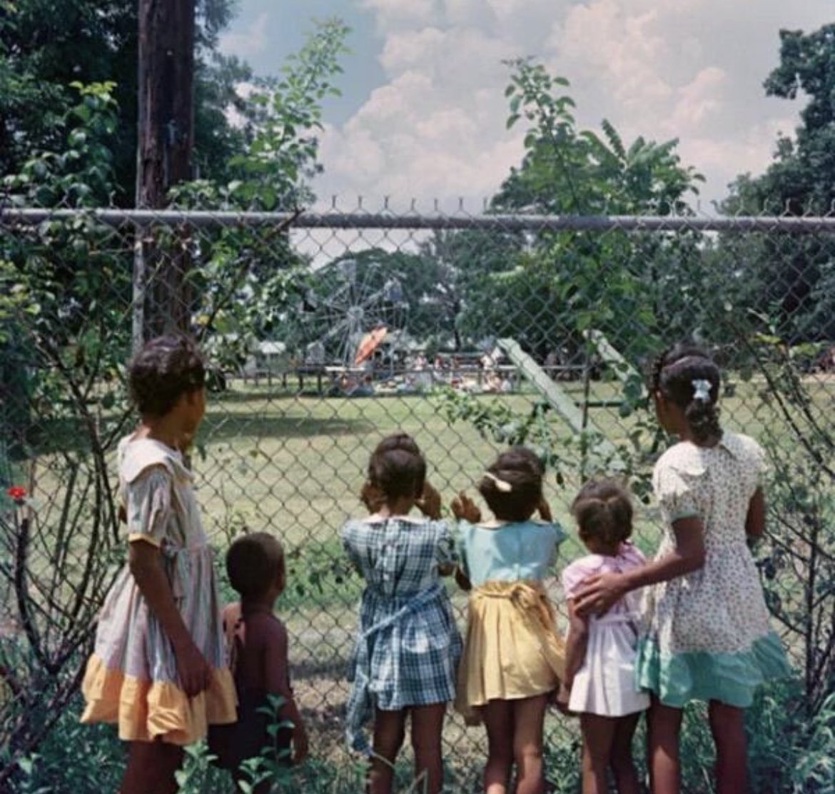 MorbidKnowledge's tweet photo. Photograph taken by Gordon Parks in 1956 shows black children watching as white children play in a white only park. https://t.co/QFxevyOzfL