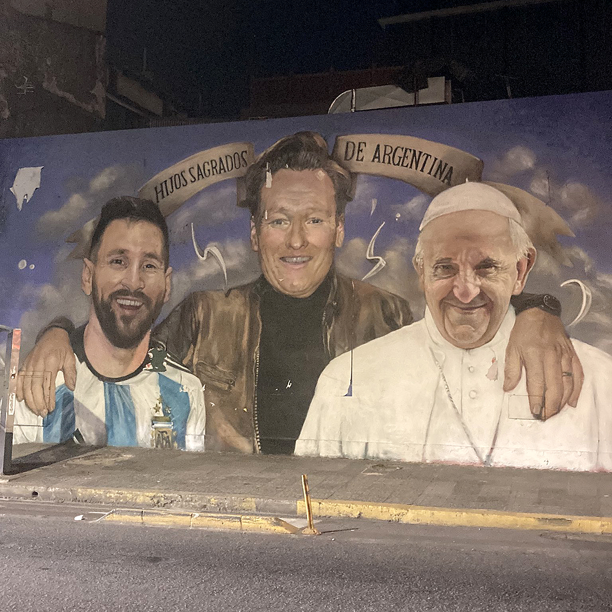 MenInBlazers's tweet photo. A mural in Buenos Aires featuring Messi, The Pope and...Conan O'Brien. Argentina still drunk from the World Cup. https://t.co/WGst9vabWx