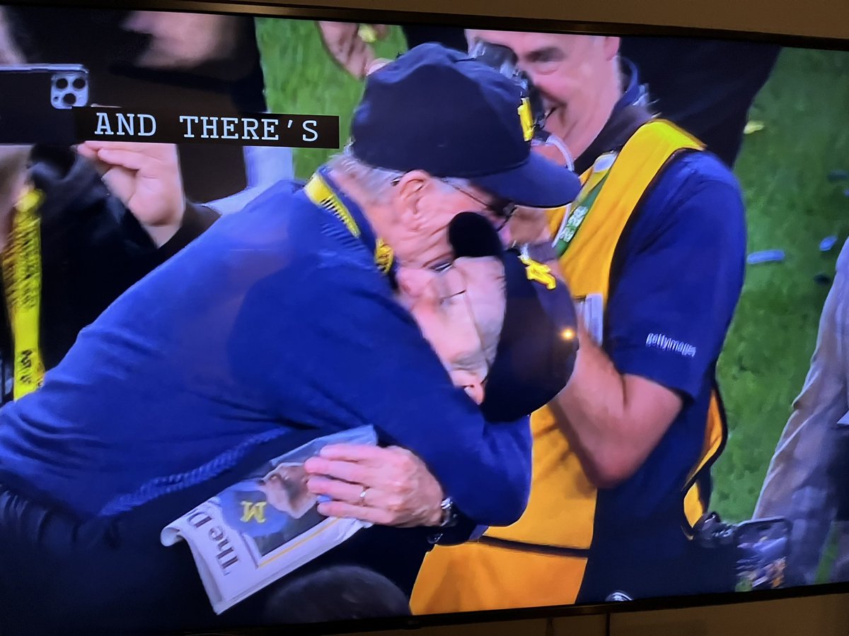 ChadLivengood's tweet image. Jack Harbaugh, father of @CoachJim4UM, carrying the @detroitnews field edition of @UMichFootball’s national championship as he hugs his son.