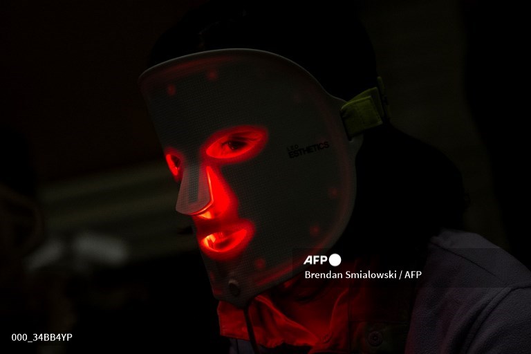 A person wears a red light mask from Light Tree Ventures during Pepcom's Digital Experience at the The Mirage resort during the Consumer Electronics Show (CES) in Las Vegas, Nevada. A picture by #AFP photographer Brendan Smialowski