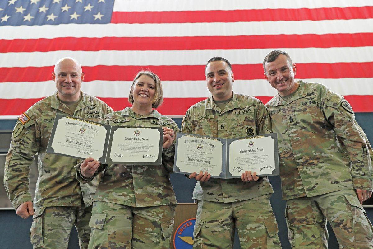 SFCs Ashley J. and Ronold P. Hogge, 1-13th Aviation Regiment, display their certificates of enlistment with Lt. Col. Norland, left, and Command Sgt. Maj. McAvoy, 1-13th Aviation Regiment command team, at the U.S. Army Aviation Museum, Fort Novosel, Ala., Dec. 5, 2023.