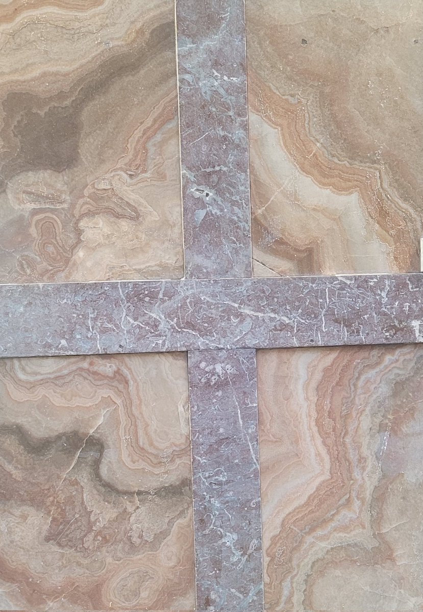 Cruz en falsa ágata (espeletemas, de fondo) y caliza roja fosilífera (en relieve), en la fachada de un establecimiento tradicional en la calle Ponzano de Madrid. Evidentemente, es una farmacia ...