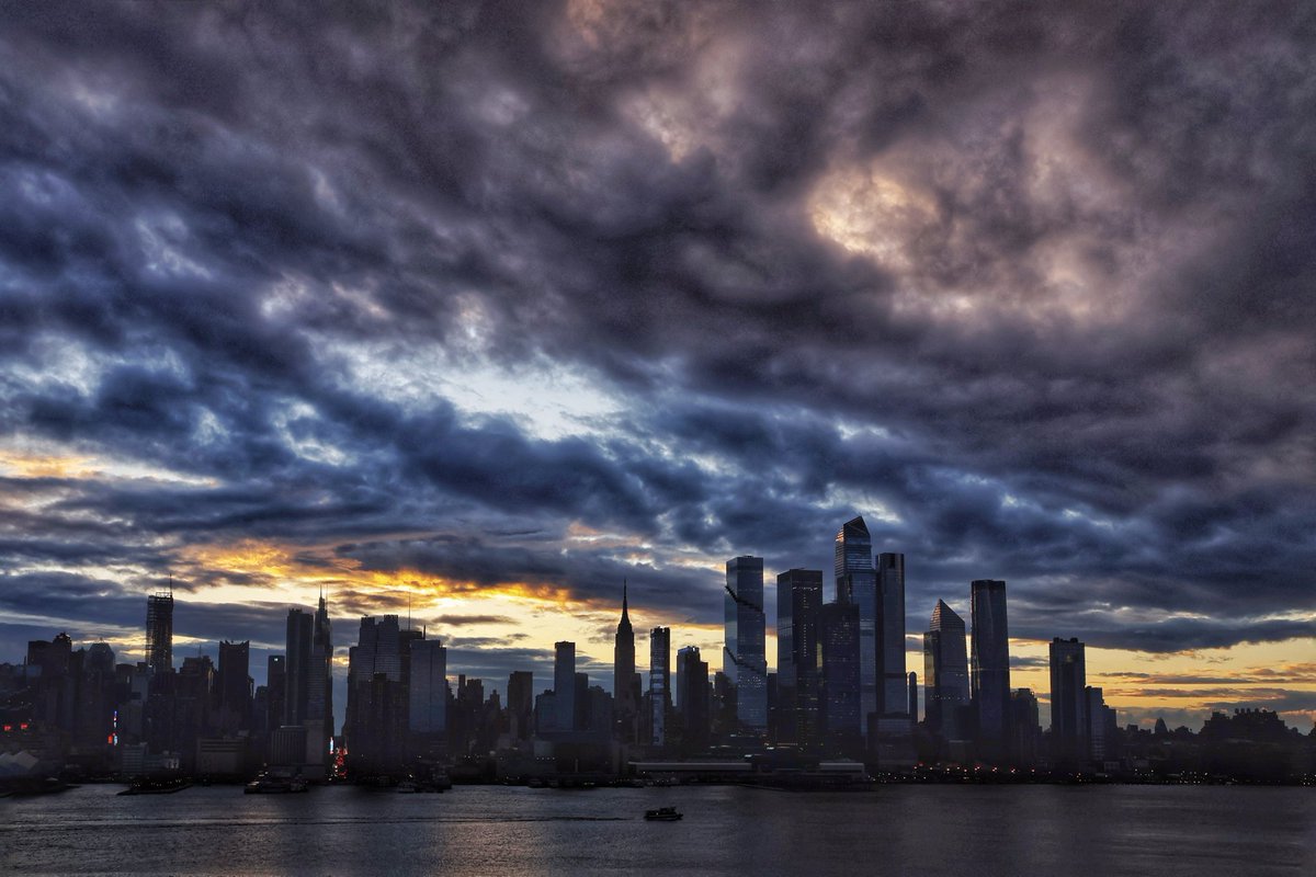 GaryHershorn's tweet photo. Storm clouds clear out of midtown Manhattan as the sun rises in New York City, Wednesday morning #nyc #newyork #NewYorkCity #sunrise https://t.co/1KcAWpeOlz
