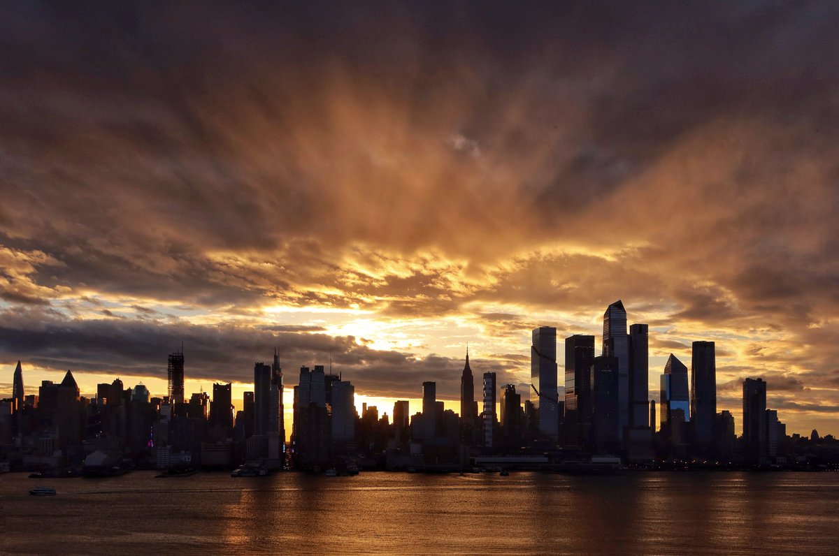 GaryHershorn's tweet photo. Storm clouds clear out of midtown Manhattan as the sun rises in New York City, Wednesday morning #nyc #newyork #NewYorkCity #sunrise https://t.co/1KcAWpeOlz